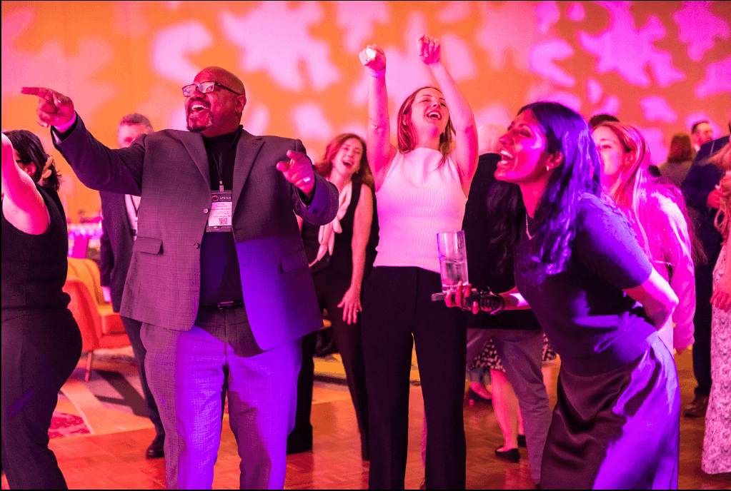 A group of people dancing and celebrating at a soiree event.