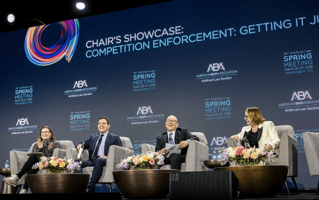 Panelists sitting on a stage, laughing and smiling